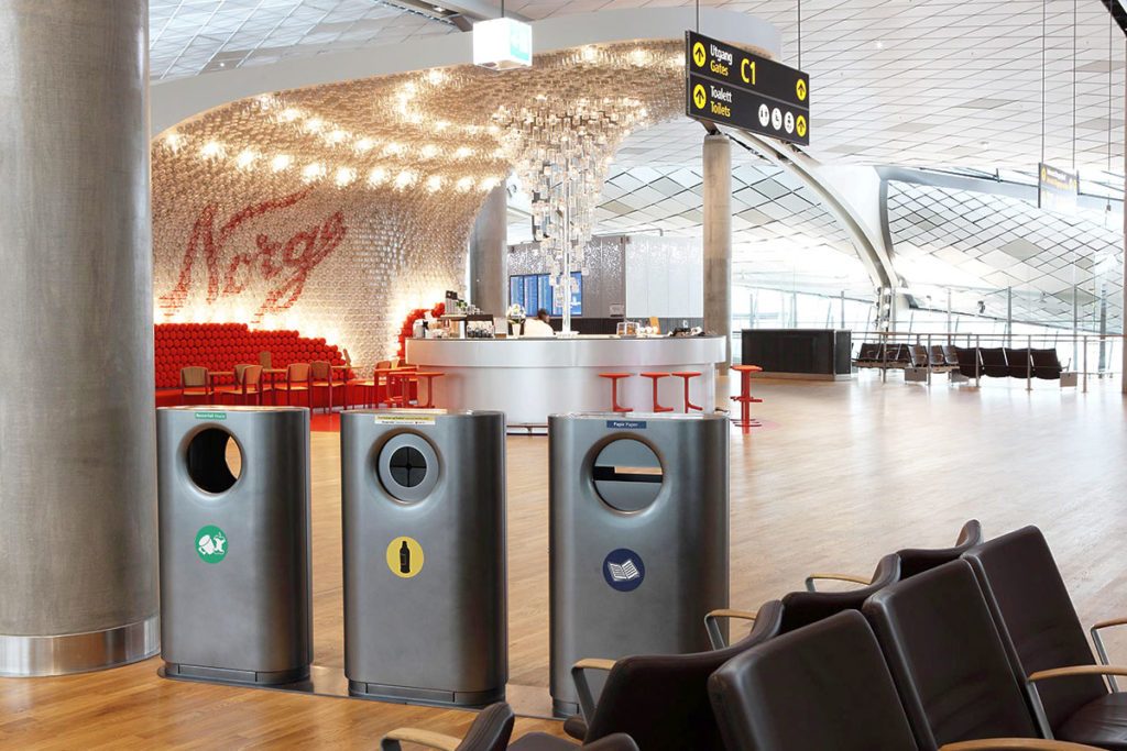 tre konsis avfallsbeholdere i en hall på oslo lufthavn